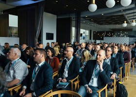 Business professionals attentively listening at an indoor conference meeting.